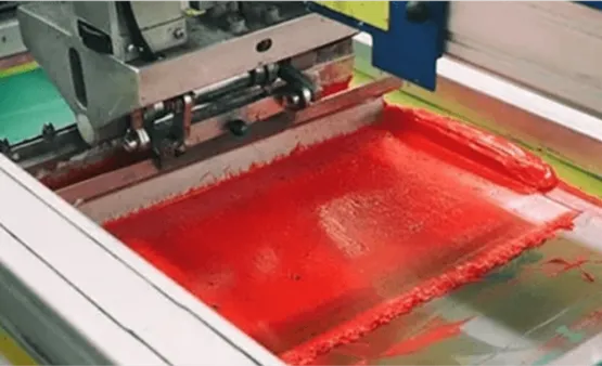 A tray of 'HORSESAFE' red labels being processed on a metal sheet.
